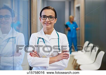 Portrait of doctor in hallway, arms folded, smiling View Large Photo Image Stock Photograph - Portrait of doctor in hallway, arms folded, smiling. Fotosearch
