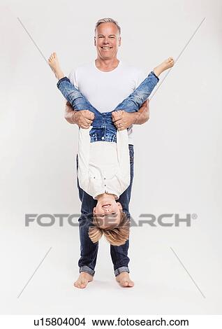 Picture - Portrait of father with son held upside down. Fotosearch