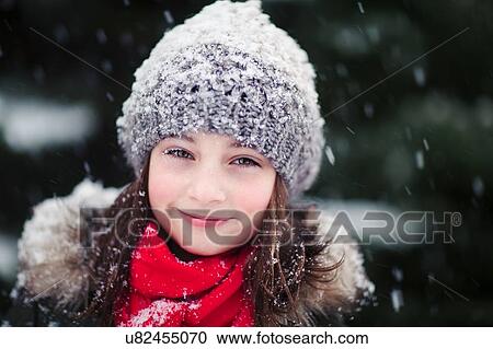 Stock Image - Portrait of girl in falling snow. Fotosearch