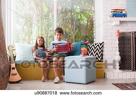 Portrait of girl on window seat with boy practicing accordion View Large Photo Image Stock Photo - Portrait of girl on window seat with boy practicing accordion. Fotosearch