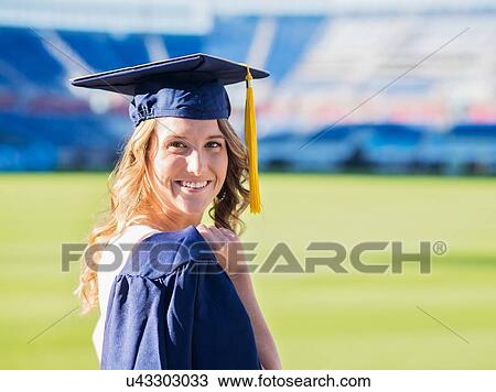 Stock Image - Portrait of graduate student in stadium. Fotosearch