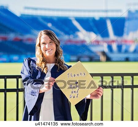 Stock Photography - Portrait of graduate student showing message on mortarboard. Fotosearch
