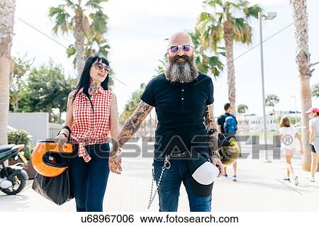 Stock Photograph - Portrait of mature hipster couple strolling on sidewalk, Valencia, Spain. Fotosearch