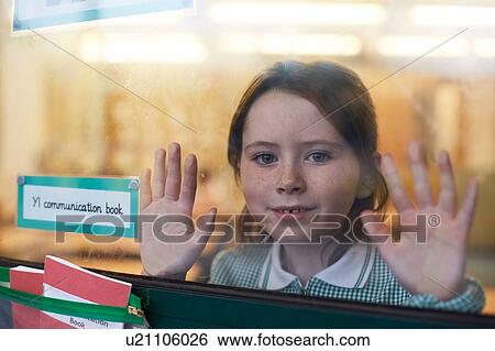 Portrait of schoolgirl with hands on classroom window at primary school View Large Photo Image Stock Photograph - Portrait of schoolgirl with hands on classroom window at primary school. Fotosearch