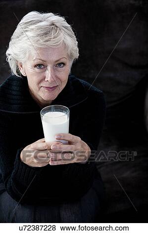 Portrait of senior woman, holding glass of milk View Large Photo Image Stock Photo - Portrait of senior woman, holding glass of milk. Fotosearch