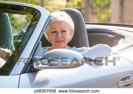 Stock Photo - Portrait of senior woman in convertible car. Fotosearch
