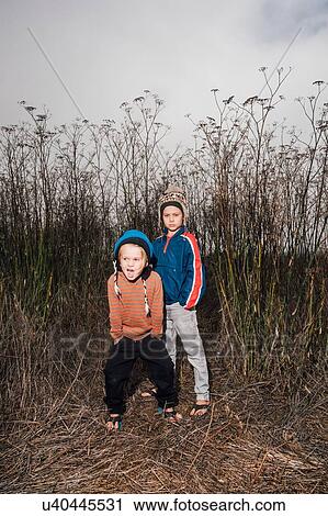 Portrait of two brothers, outdoors, in rural setting, wearing knitted hats, View Large Photo Image Stock Image - Portrait of two brothers, outdoors, in rural setting, wearing knitted hats,. Fotosearch