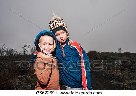 Portrait of two brothers, outdoors, wearing knitted hats, arms around each other View Large Photo Image Stock Image - Portrait of two brothers, outdoors, wearing knitted hats, arms around each other. Fotosearch