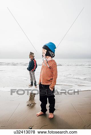 Portrait of two brothers, standing on beach, wearing knitted hats View Large Photo Image Stock Photo - Portrait of two brothers, standing on beach, wearing knitted hats. Fotosearch