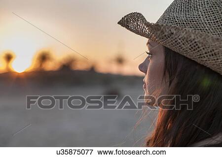 Portrait of woman wearing straw hat looking away View Large Photo Image Stock Photo - Portrait of woman wearing straw hat looking away. Fotosearch
