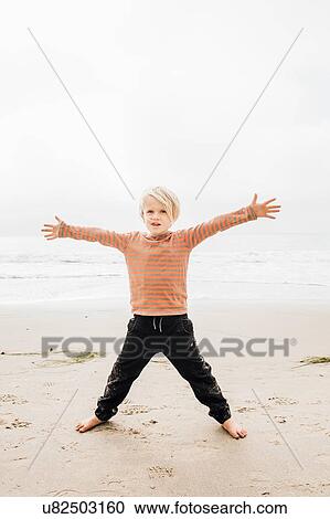 Portrait of young boy on beach, arms outstretched View Large Photo Image Stock Image - Portrait of young boy on beach, arms outstretched. Fotosearch