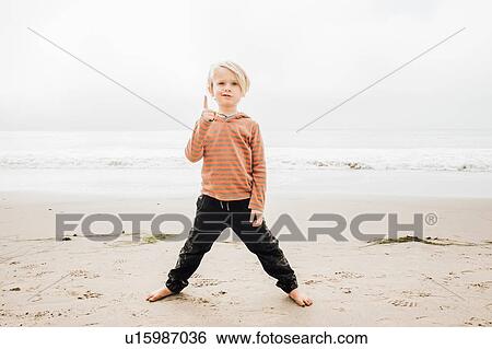 Portrait of young boy on beach, finger raised View Large Photo Image Stock Photograph - Portrait of young boy on beach, finger raised. Fotosearch