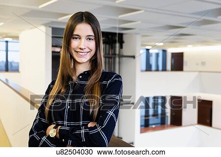 Stock Image - Portrait of young businesswoman in office atrium. Fotosearch