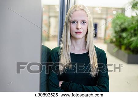 Portrait of young businesswoman with arms folded at office entrance View Large Photo Image Stock Photography - Portrait of young businesswoman with arms folded at office entrance. Fotosearch