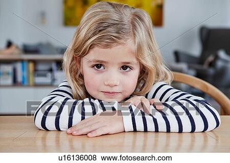 Portrait of young girl, sitting at table, pensive expression View Large Photo Image Stock Photo - Portrait of young girl, sitting at table, pensive expression. Fotosearch
