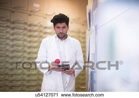 Portrait of young male pharmacist using digital tablet in pharmacy View Large Photo Image Stock Image - Portrait of young male pharmacist using digital tablet in pharmacy. Fotosearch