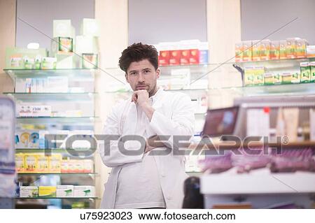 Portrait of young male pharmacist with hand on chin in pharmacy View Large Photo Image Stock Image - Portrait of young male pharmacist with hand on chin in pharmacy. Fotosearch