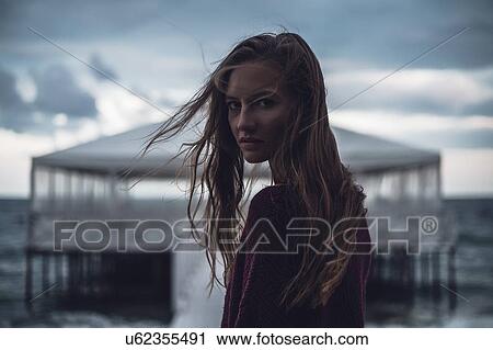 Portrait of young woman with flyaway hair on pier at dusk, Odessa Oblast, Ukraine View Large Photo Image Stock Image - Portrait of young woman with flyaway hair on pier at dusk, Odessa Oblast, Ukraine. Fotosearch