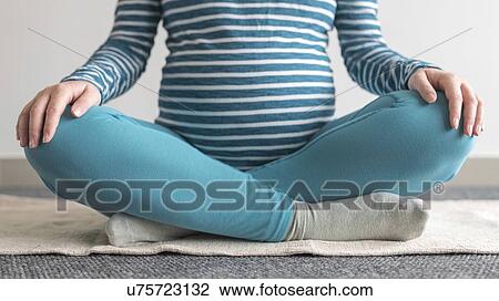 Stock Image - Pregnant woman practicing yoga.. Fotosearch
