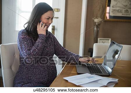 Pregnant woman using laptop and smart phone at home View Large Photo Image Stock Photography - Pregnant woman using laptop and smart phone at home. Fotosearch
