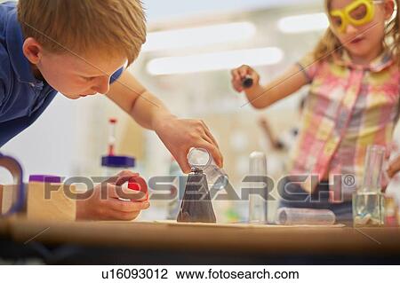 Primary schoolboy and girl doing test tube experiment in classroom View Large Photo Image Stock Image - Primary schoolboy and girl doing test tube experiment in classroom. Fotosearch