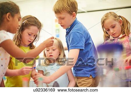 Stock Photo - Primary schoolboy and girls doing teamwork project in classroom. Fotosearch