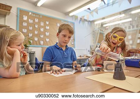 Primary schoolgirls and boy doing experiment at classroom desk View Large Photo Image Stock Image - Primary schoolgirls and boy doing experiment at classroom desk. Fotosearch