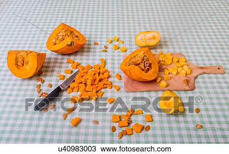Pumpkin cut into pieces on chopping board with knife View Large Photo Image Stock Image - Pumpkin cut into pieces on chopping board with knife. Fotosearch