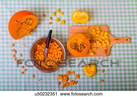 Pumpkin cut into pieces on chopping board with bowl full of cubed pumpkin, overhead view View Large Photo Image Stock Image - Pumpkin cut into pieces on chopping board with bowl full of cubed pumpkin, overhead view. Fotosearch
