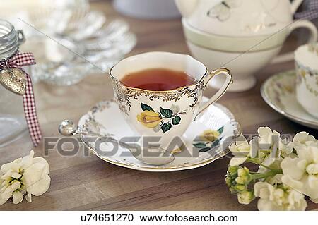 Stock Image - Quaint teacup and saucer on table. Fotosearch