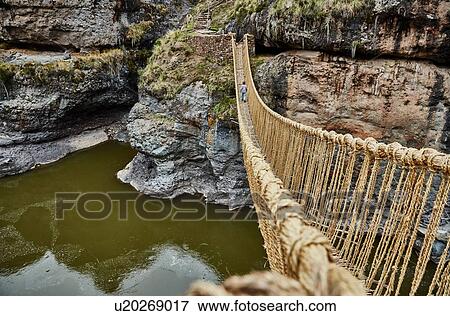 Stock Photo - Rear view of boy crossing Inca rope bridge, Huinchiri, Cusco, Peru. Fotosearch