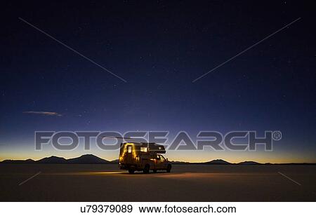 Stock Photo - Recreational vehicle, travelling at dusk, across salt flats, Salar de Uyuni, Uyuni, Oruro, Bolivia, South America. Fotosearch