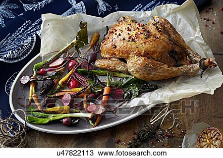 Stock Image - Roast chicken and vegetables on serving tray. Fotosearch