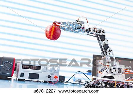 Stock Photo - Robotic arm holding apple.. Fotosearch