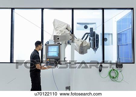 Robotics engineer operating robot cutting machine in robotics research facility View Large Photo Image Stock Image - Robotics engineer operating robot cutting machine in robotics research facility. Fotosearch