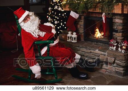 Santa Claus, sleeping in chair beside fireplace View Large Photo Image Stock Photo - Santa Claus, sleeping in chair beside fireplace. Fotosearch