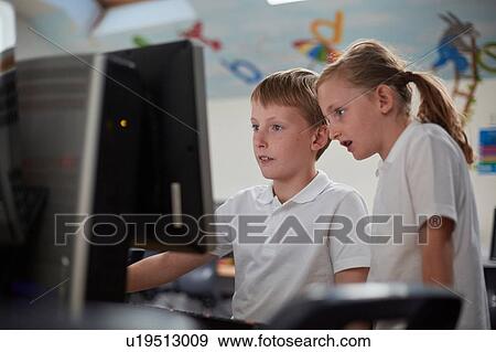 Schoolboy and girl using computer in classroom at primary school View Large Photo Image Stock Photo - Schoolboy and girl using computer in classroom at primary school. Fotosearch