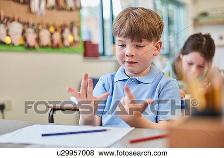 Schoolboy counting with fingers in classroom lesson at primary school View Large Photo Image Stock Photo - Schoolboy counting with fingers in classroom lesson at primary school. Fotosearch