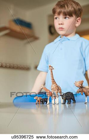 Stock Photography - Schoolboy with toy animals in classroom at primary school. Fotosearch