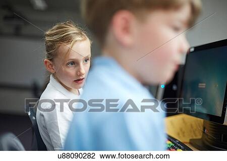 Schoolgirl and boy using computers in classroom at primary school View Large Photo Image Stock Image - Schoolgirl and boy using computers in classroom at primary school. Fotosearch