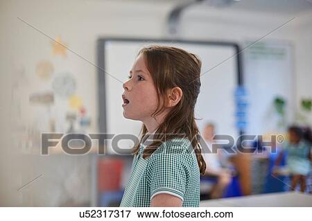 Schoolgirl answering in class at primary school View Large Photo Image Stock Photo - Schoolgirl answering in class at primary school. Fotosearch