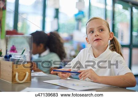 Schoolgirl looking up in classroom lesson at primary school View Large Photo Image Stock Image - Schoolgirl looking up in classroom lesson at primary school. Fotosearch