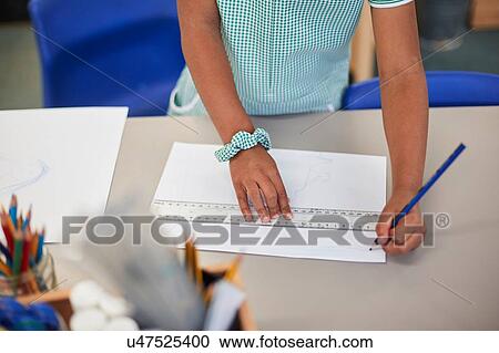 Schoolgirl using ruler to draw at classroom desk in primary school, cropped View Large Photo Image Stock Image - Schoolgirl using ruler to draw at classroom desk in primary school, cropped. Fotosearch