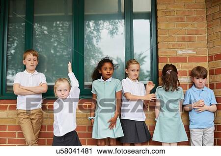 Schoolgirls and boys standing outside primary school building View Large Photo Image Stock Image - Schoolgirls and boys standing outside primary school building. Fotosearch