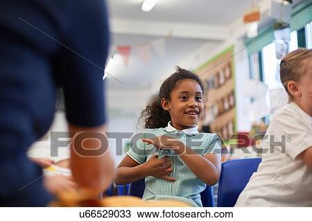 Stock Image - Schoolgirls and teacher in class at primary school, cropped. Fotosearch
