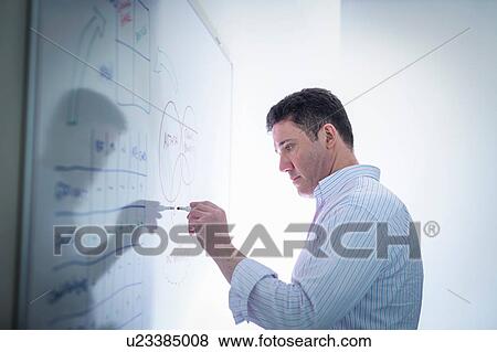Stock Photo - Scientist drawing on white board in meeting room. Fotosearch