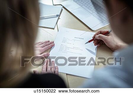 Stock Image - Scientists signing Chinese contract about pharmaceutical project in meeting room, over shoulder view. Fotosearch