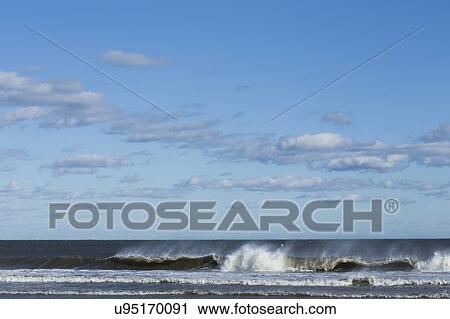 Stock Image - Sea waves splashing onto beach. Fotosearch