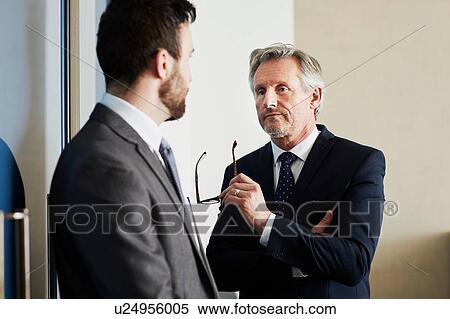 Stock Photography - Senior businessman meeting male colleague in office. Fotosearch
