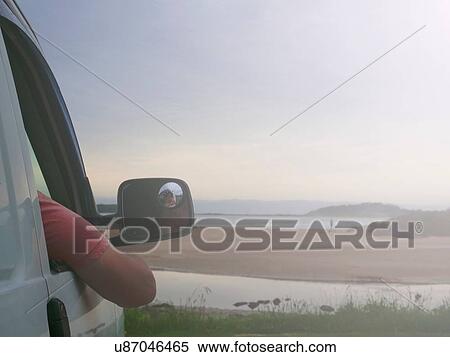 Stock Photography - Senior man sitting in car, looking at coastal view, Broulee, New South Wales, Australia. Fotosearch